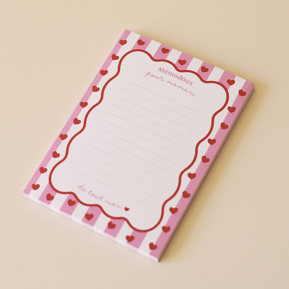 Bloc-notes papier
Portrait rectangulaire
Modèle cadre rayé rose, contour vague rouge, coeurs rouges
Inscription haut sur 2 lignes « Mémodoux pour maman »
Inscription bas « jusqu’au étoiles »
12 lignes à intervale réguliers